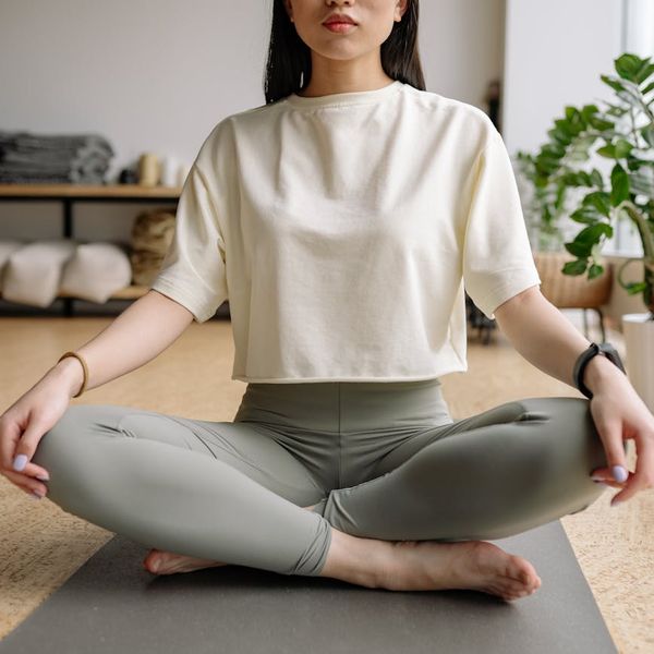 Person sitting in a meditative yoga pose, focusing inward.