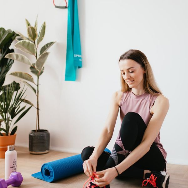 Yoga mat rolled up next to a water bottle and a small towel.